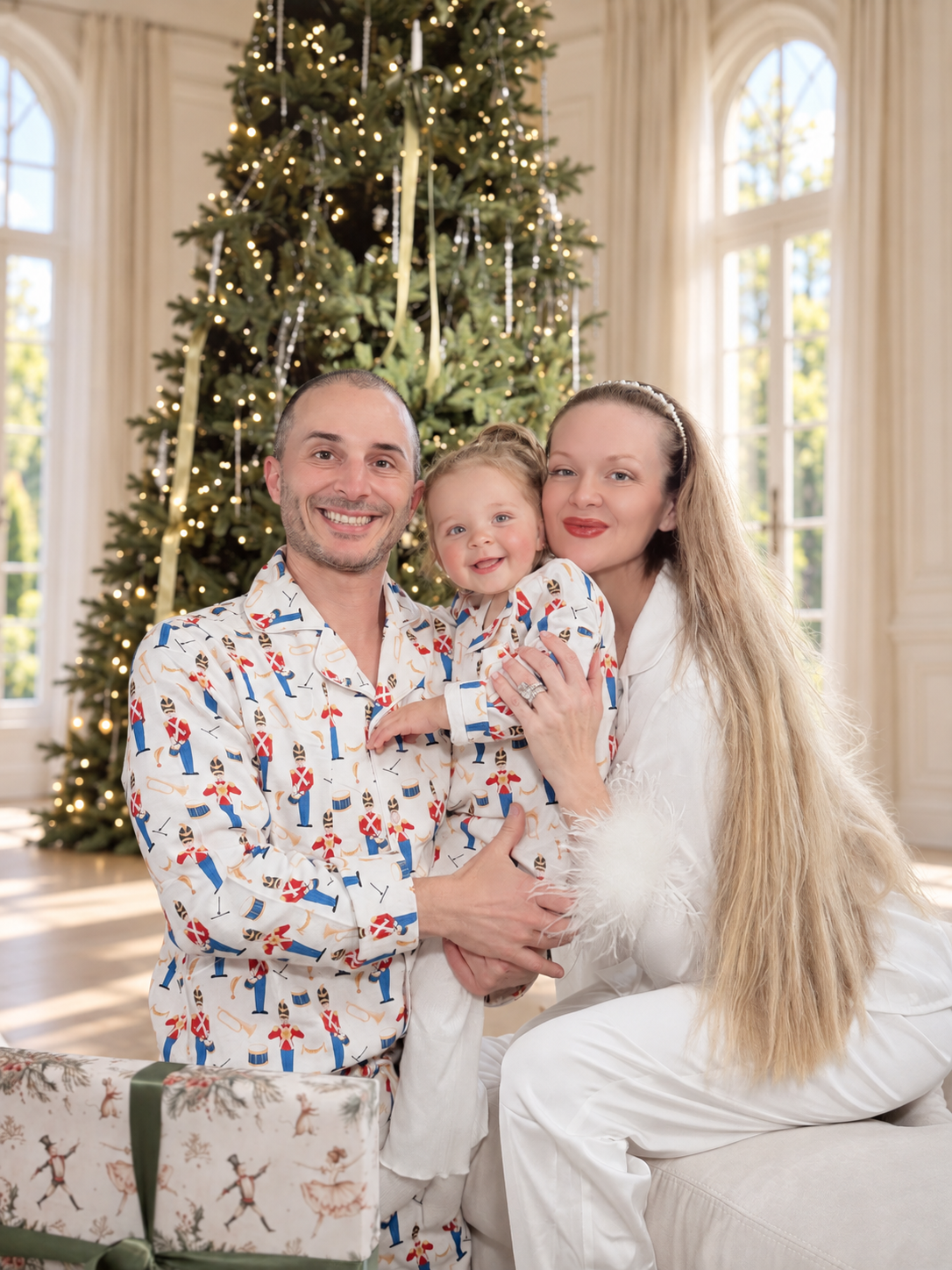 Charlotte, her husband and their daughter together beside the Christmas tree.