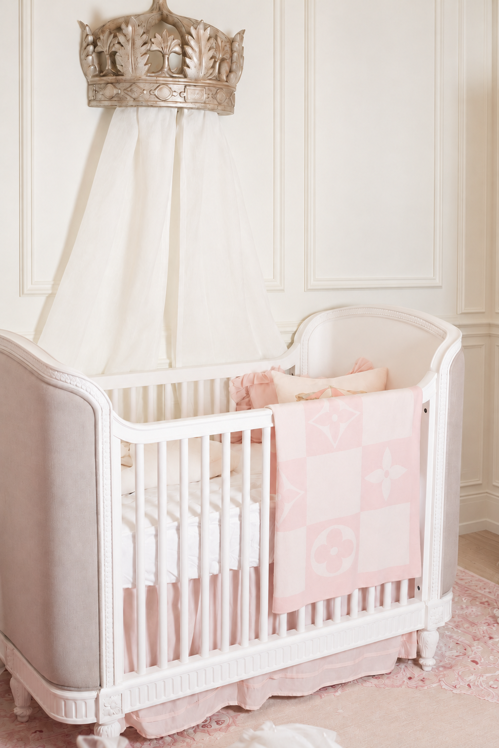 Madison’s ivory crib, crown canopy, and blush blanket in her Parisian-inspired nursery.
