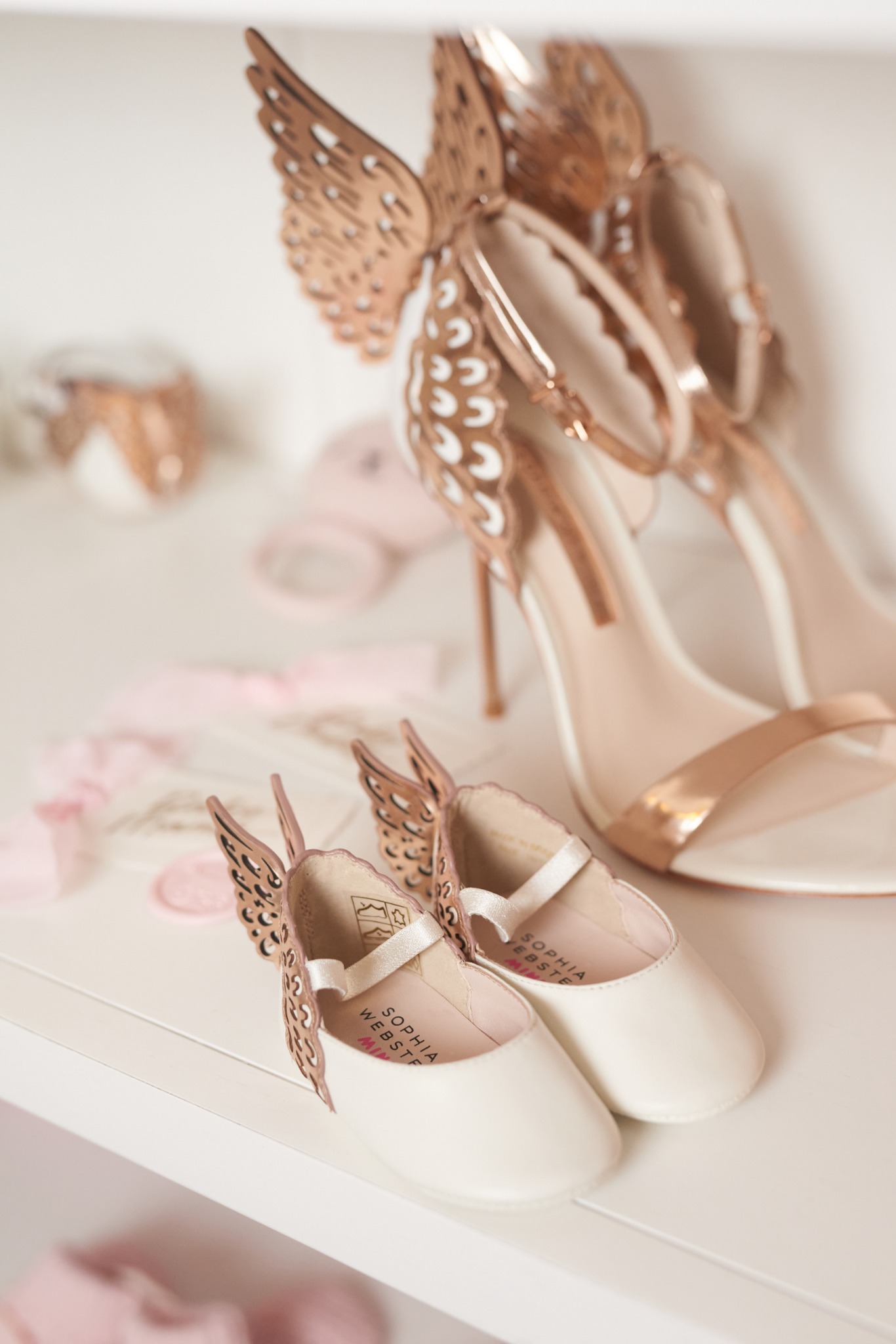Madison’s ivory butterfly baby shoes beside Charlotte’s matching rose-gold butterfly heels.